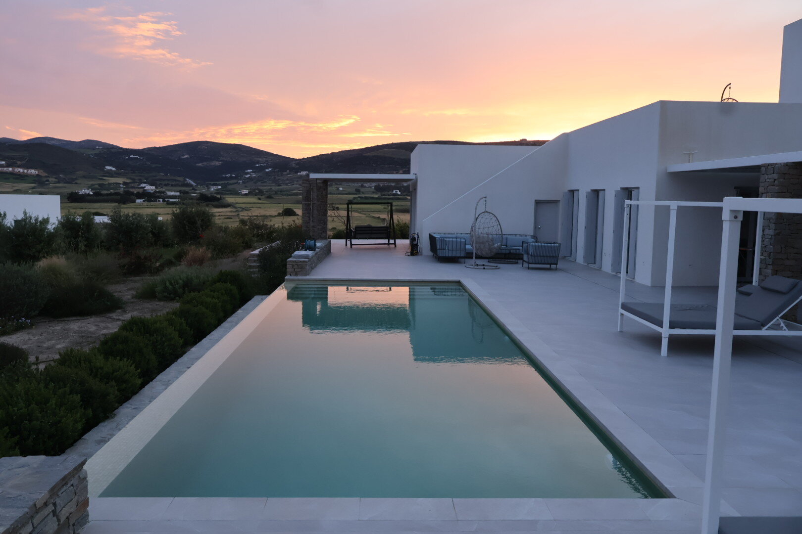 Coucher de soleil rose sur les collines de Paros depuis la piscine de la Villa Ariadni